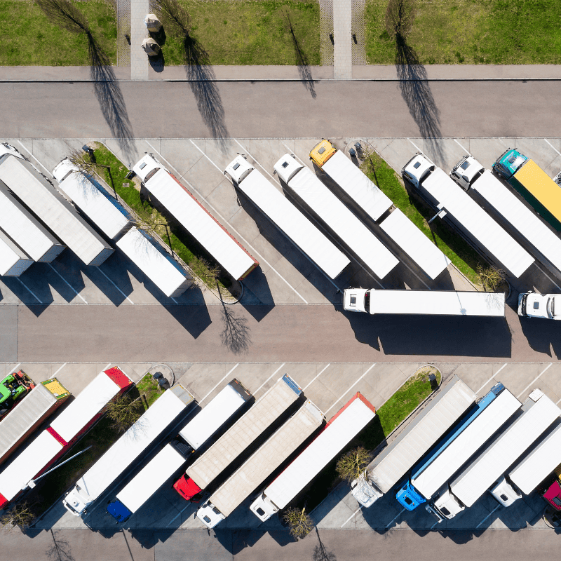 Semi-trucks idling in a large parking lot